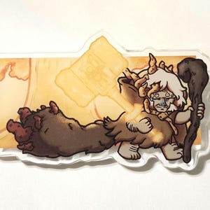 May include: A clear acrylic sticker featuring a cartoon character with a hammer and staff. The character has light brown fur, white hair, and a serious expression. The background is a light orange color.
