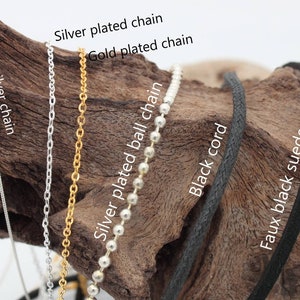 May include: Close-up of six different types of chain and cord, including sterling silver chain, gold plated chain, silver plated chain, silver plated ball chain, black cord, and faux black suede.