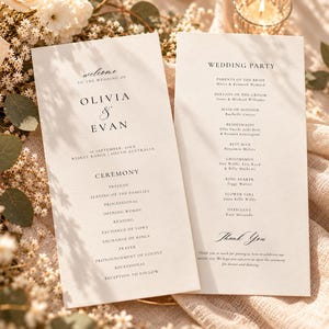 Puede incluir: Dos tarjetas de programa de boda en color blanco roto con texto negro en fuentes serif y manuscrita. La tarjeta izquierda detalla el orden de la ceremonia de Olivia y Evan, y la derecha enumera a los miembros de la corte nupcial.