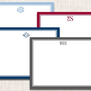 May include: Four personalized stationery cards in various colors: light blue, navy, burgundy, and gray. Each card features a white interior with a monogram in the upper center. The borders are in matching colors, creating a cohesive and elegant design.