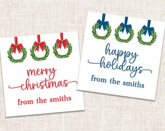 May include: Two square white gift tags featuring green Christmas wreaths with red or blue bows. The left tag reads merry christmas from the smiths in red text. The right tag reads happy holidays from the smiths in blue text with matching bows.