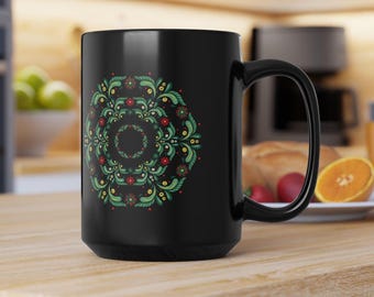 Könnte beinhalten: Schwarze Keramik-Kaffeetasse mit einem grünen, roten und gelben floralen Mandala-Design.