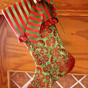 May include: A red and green Christmas stocking with a striped bow and a green and red damask pattern.