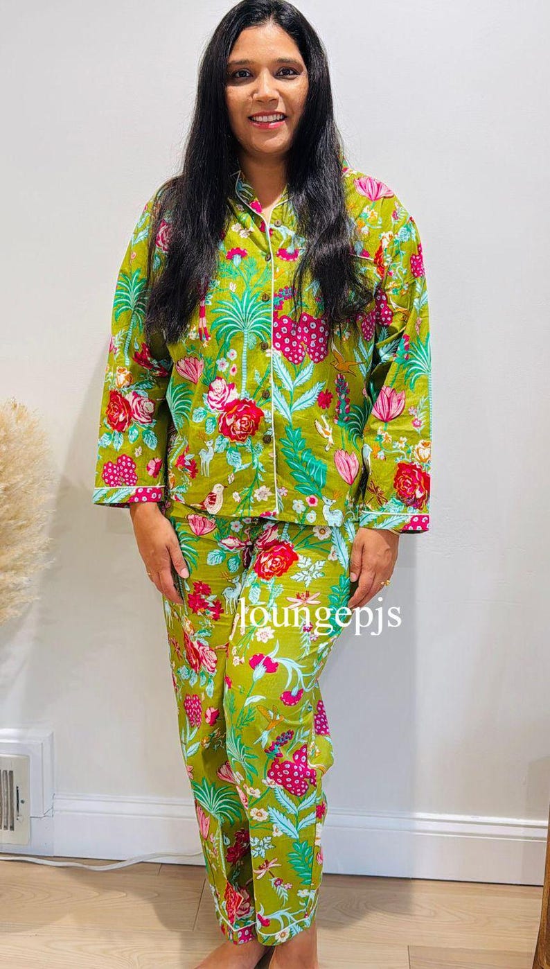 May include: A green and white floral print pyjama set with long sleeves and trousers. The top has a button-up front and a white trim. The trousers have a drawstring waist. The text "loungepjs" is visible on the trousers.