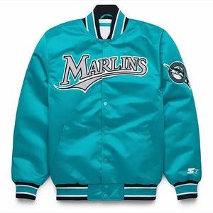 May include: Teal satin jacket with the word "Marlins" in white and gray lettering across the chest. The jacket has a black, white, and teal striped collar, cuffs, and hem. A team logo patch is on the right sleeve, and a Starter logo is on the left cuff.
