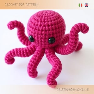 May include: A pink crocheted octopus amigurumi toy with black eyes. The octopus has eight tentacles and is sitting on a white background.