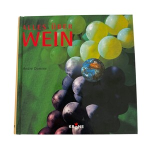 Può includere: Un libro con copertina rigida intitolato "ALLES ÜBER WEIN" con il nome dell'autore, André Domine, sulla copertina. La copertina presenta un'immagine vibrante di uva verde, gialla e viola. Il libro ha uno sfondo verde.