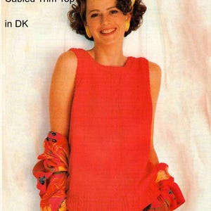 May include: A sleeveless, red, cable-trimmed top. The image also shows a colorful patterned skirt and a scarf. The text in the image reads "Sleeveless Cabled Trim Top in DK".