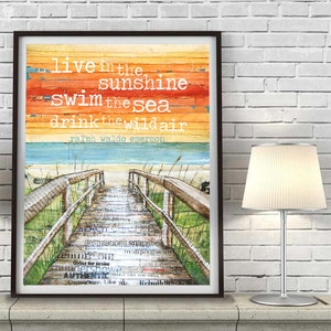 May include: A watercolour painting of a wooden walkway leading to a beach with a quote by Ralph Waldo Emerson: "live in the sunshine swim the sea drink the wild air".