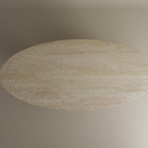 Puede incluir: Mesa ovalada de piedra beige claro. La mesa tiene una superficie lisa y pulida con vetas sutiles y está sobre un fondo neutro. La forma y el color de la mesa sugieren un diseño moderno y minimalista.