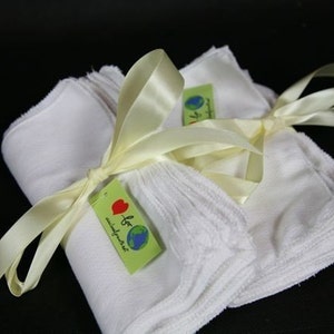 May include: A stack of white cloth baby wipes tied with a yellow ribbon and a green tag that says "I love minimalist".