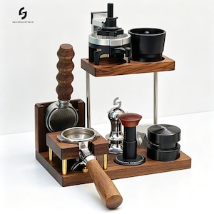 Op de afbeelding: Een houten espressostation met een standaard met twee niveaus, een filterdragerhouder, een metalen tamper, een zwarte distributietool en een zilveren puck-screen. De set bevat een donkerhouten basis met gouden accenten en een houten handvat.
