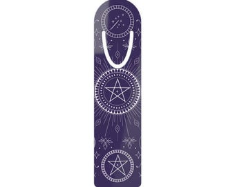 Puede incluir: Un marcapáginas vertical de parte superior redondeada en color morado oscuro con dibujos de líneas blancas. El diseño incluye dos motivos circulares de pentagramas, líneas radiantes, pequeños diamantes y una estrella fugaz.