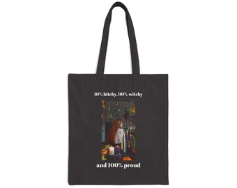 May include: Black tote bag with the text "10% bitchy, 90% witchy and 100% proud." The bag features an image of a person with long red hair, surrounded by candles and dried herbs. The bag has two black handles.
