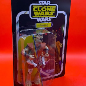 以下が含まれることがあります： スター・ウォーズ：クローン・ウォーズのポング・クレルのアクションフィギュア。黒と白のカードにパッケージされています。フィギュアは透明なプラスチックのブリスターに入っています。カードにはスター・ウォーズのロゴと小さな部品に関する警告が表示されています。