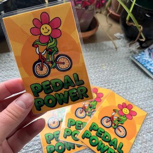 hand holding laminated card with riding bike