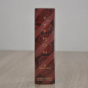 May include: A red and gold bottle of Trussardi Python Sensual Deodorant. The bottle has a snake skin pattern and the text "Python" is written vertically in gold letters. The bottle is 50 ml or 1.7 fl. oz.