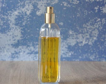 May include: A clear glass bottle of Ysatis de Givenchy perfume with a gold spray nozzle and cap. The bottle is filled with a yellow liquid.
