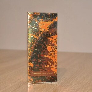 May include: A gold box with a brown and orange marbled pattern. The box has the text "Montagut International" printed on the front.