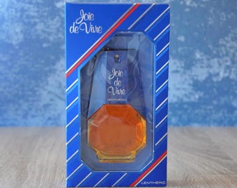 May include: A blue and red box with a clear glass bottle of Joye de Vivre perfume by Lentheric. The bottle is shaped like a diamond and has a gold cap.