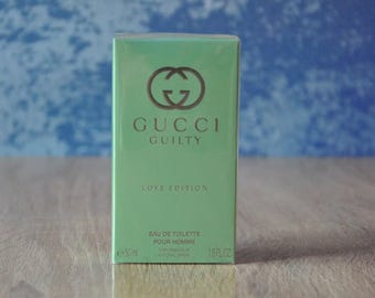 May include: A rectangular, light green box of Gucci Guilty Love Edition Eau de Toilette for men. The box features the Gucci logo and the words "GUCCI GUILTY LOVE EDITION". The box contains 1.6 fl oz (50ml) of product.