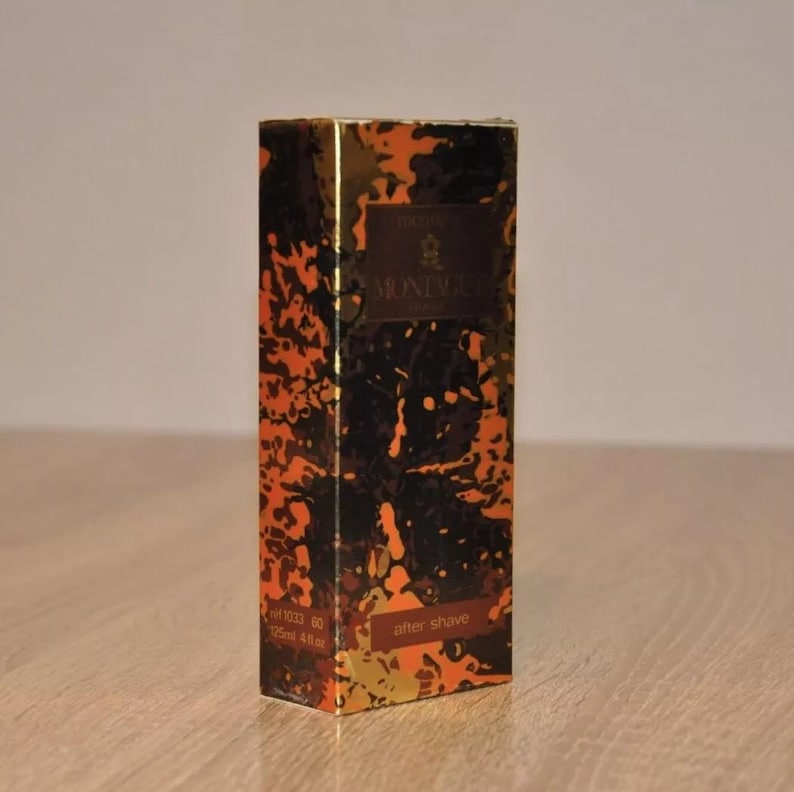 May include: A brown and gold aftershave bottle with a black and gold abstract design. The bottle is labeled "Original" and "BRUNI" with the text "after shave" on the bottom. The bottle is 125 ml or 4.2 fl oz.