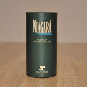 May include: A green cylindrical bottle with a white label that reads "NIAGARA EAU DE TOILETTE POUR HOMMES VAPORISATEUR - NATURAL SPRAY" and a logo that reads "COURREGES PARIS".