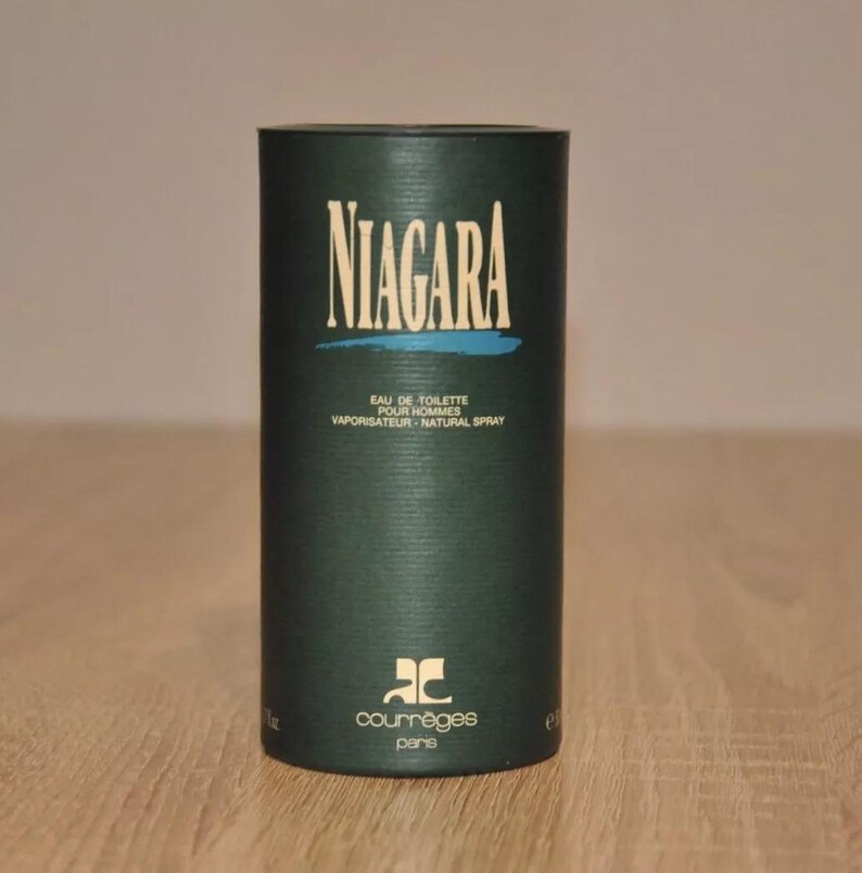 May include: A green cylindrical bottle with a white label that reads "NIAGARA EAU DE TOILETTE POUR HOMMES VAPORISATEUR - NATURAL SPRAY" and a logo that reads "COURREGES PARIS".