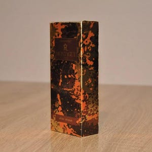 May include: A gold and black aftershave bottle with a camouflage pattern and the text "MONTIQUE" on the front.