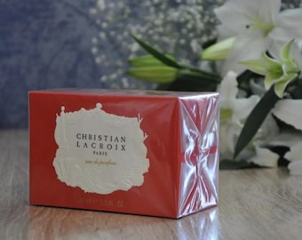 May include: A red box with a white label that says "Christian Lacroix Paris Eau de Parfum 2.5 fl oz".