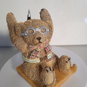 Item de colecionador de enfeites de ursinho de pelúcia, “Benjamin Hatbox”, andando de trenó, um personagem da série “Postcards from Anderby Creek”.