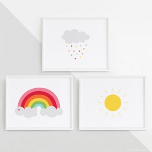 May include: Three framed prints with a rainbow, a sun, and a cloud with raindrops. The rainbow is multi-colored with pink, red, orange, yellow, green, blue, and purple. The sun is yellow with yellow rays. The cloud is gray with colorful raindrops.
