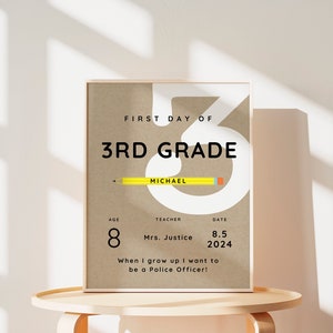 Puede incluir: Una impresión en papel marrón con el texto "First Day of 3rd Grade" y un gran número 3 blanco con un lápiz amarillo dibujado a través de él. El texto "Michael" está escrito en el lápiz. La impresión también incluye el texto "Age 8, Teacher Mrs. Justice, Date 8.5 2024". Debajo de la fecha está el texto "When I grow up I want to be a Police Officer!"