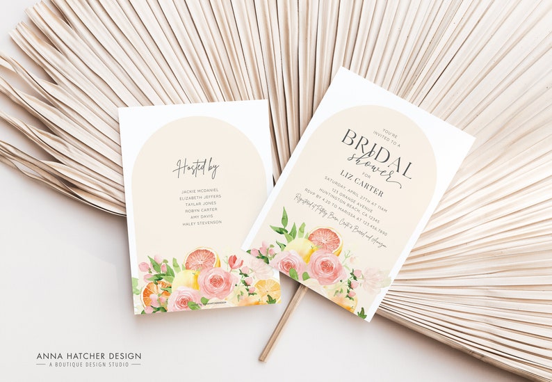 May include: A white card with a peach background and a floral design featuring lemons, oranges, and pink roses. The text on the card reads "You're invited to a Bridal Shower for Liz Carter" and includes the date, time, and location of the event.