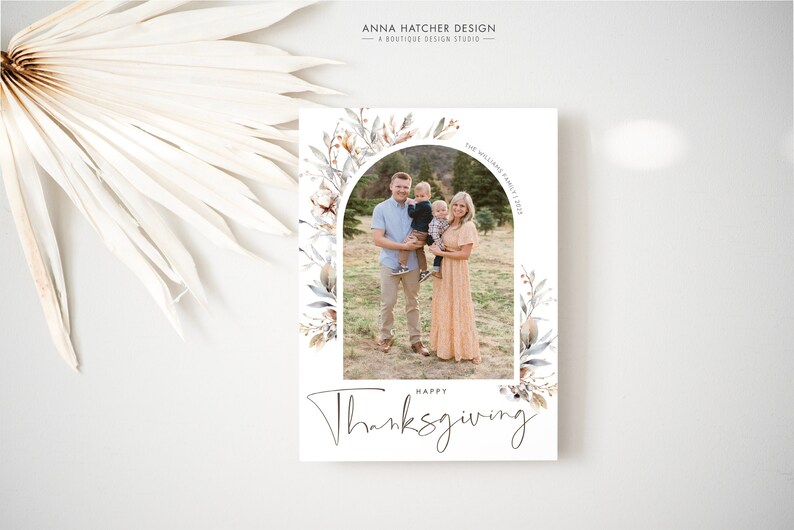 Op de afbeelding: Een Thanksgiving-kaart met een aquarel bloemenboogontwerp. De kaart bevat een foto van een gezin van vier personen dat op een veld staat. De tekst "Gelukkig Thanksgiving" staat in een handschrift onder de foto.