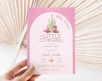 May include: Pink baby shower invitation with a watercolor illustration of a cactus, cowboy boots, and a cowboy hat. The text reads "Baby Shower", "a Little Cowgirl", "is on the way", "Paisley June", "Join us as we honor mama-to-be", "Sarah Miller", "June 22", "At 4PM", "123 Cowgirl Way | Austin, Texas 12345", "RSVP by June 16th to Katie at 123-456-7890", "Registered at Babylist.com".