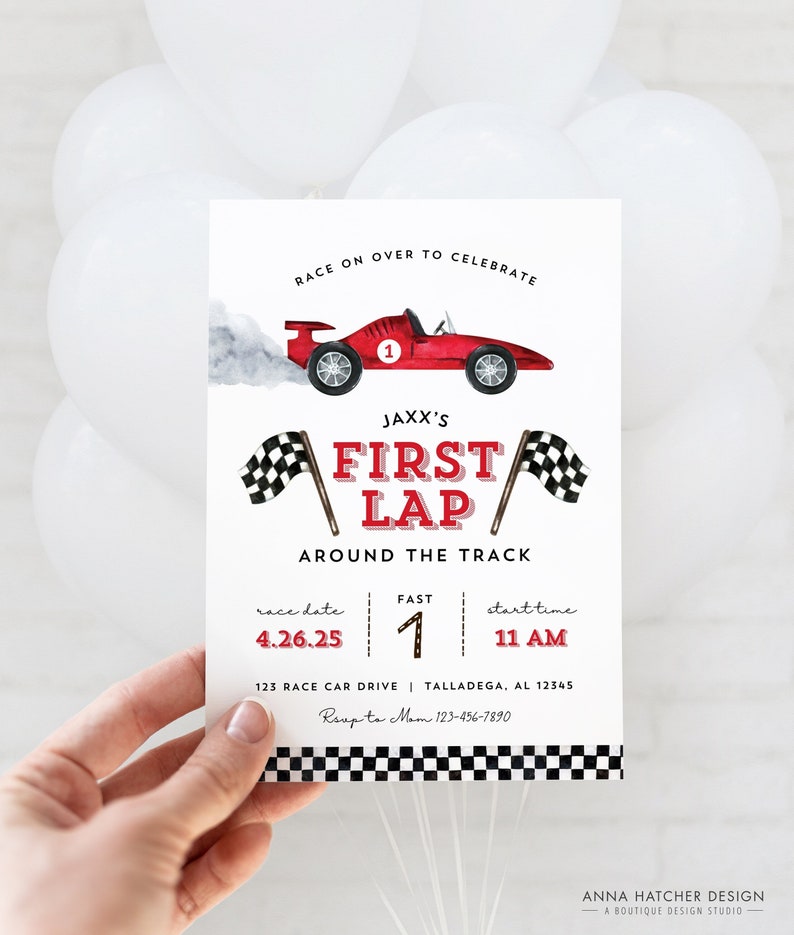 May include: A red and white race car themed invitation for a child's first birthday party. The invitation features a red race car with a checkered flag and the text "JAXX'S FIRST LAP AROUND THE TRACK". The invitation also includes the date, time, and address of the party.