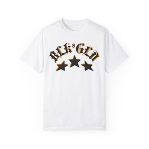 May include: White t-shirt with a black and orange graphic print of the text "BLK 8 GLN" with three black stars.