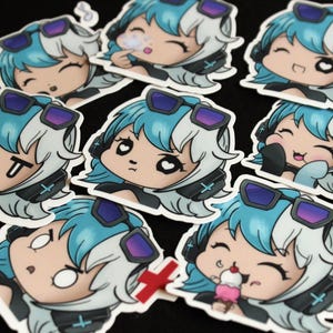 May include: A selection of anime-style stickers. Each sticker depicts a character with blue and white hair, wearing headphones and sunglasses, and displaying a different expression. Some stickers show the character blowing a bubble or eating ice cream.