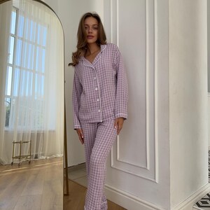 May include: A purple and white plaid pajama set with a button-up top and long pants.