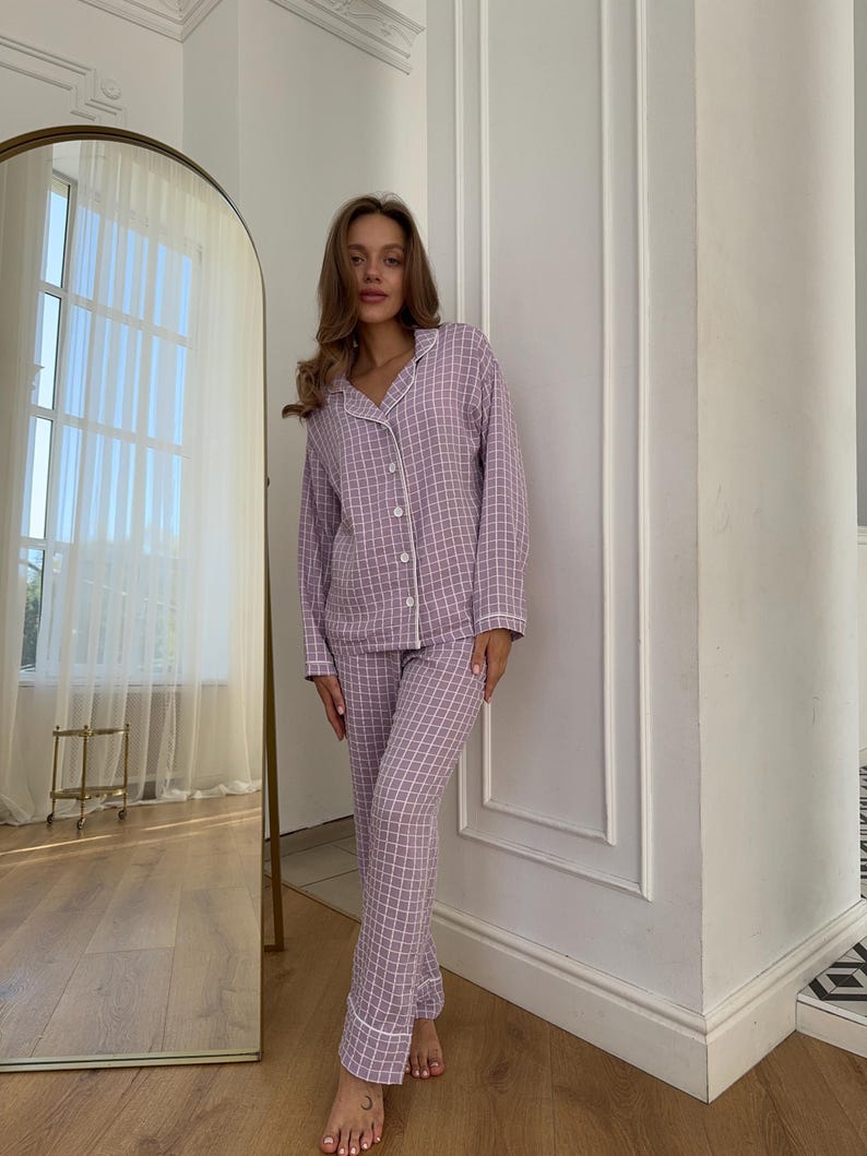 May include: A purple and white plaid pajama set with a button-up top and long pants.