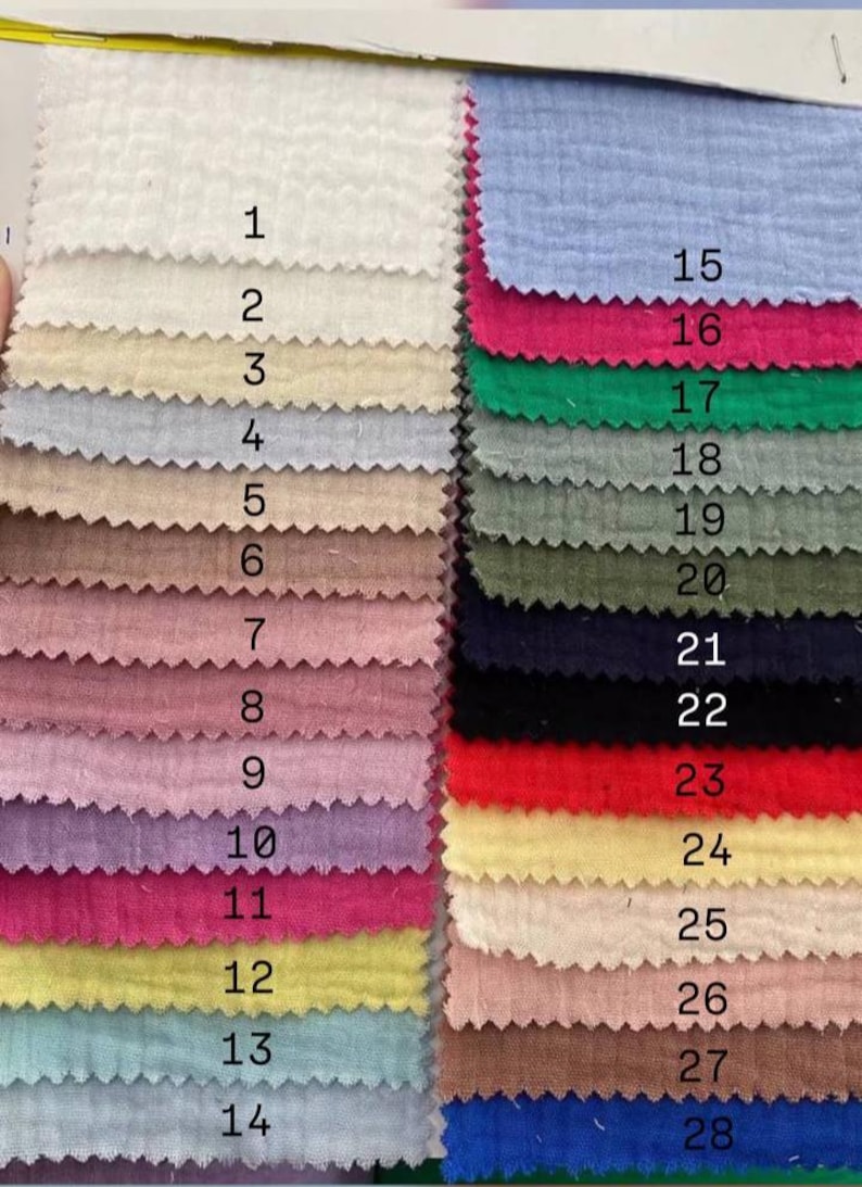 May include: A color swatch card featuring 28 fabric samples in various colors. The samples are numbered and arranged in vertical rows, showcasing a range of hues from white to blue, pink, green, and brown.
