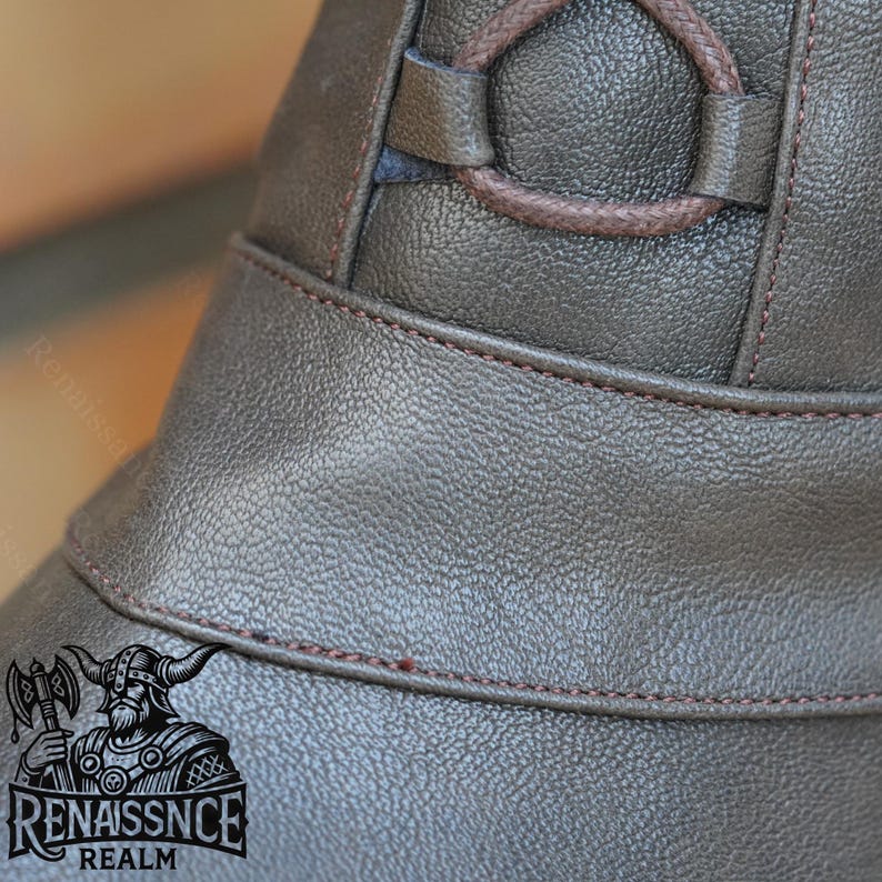 May include: Close-up of a brown leather hat with a brown leather strap and a brown leather buckle. The hat has a brown leather brim and a brown leather crown. The hat is made of a soft, supple leather.