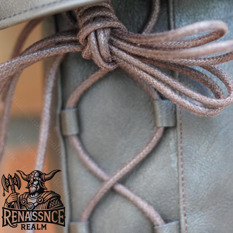 May include: Close-up of a brown leather boot with a brown lace-up closure. The laces are tied in a knot at the top of the boot.