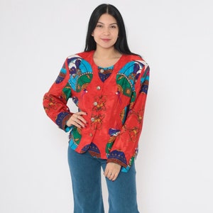 May include: A red, blue, and green patterned jacket with a button closure. The jacket is worn over a pair of blue denim jeans.