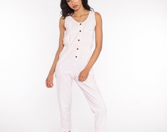 May include: A white sleeveless jumpsuit with thin pink stripes and a button-up front. The jumpsuit has a relaxed fit and cropped legs.
