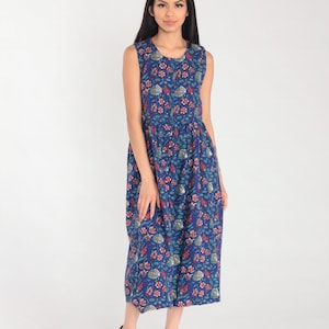 Peut inclure: Une robe maxi sans manches avec un fond bleu et un imprimé floral dans des tons de rouge, vert et blanc.