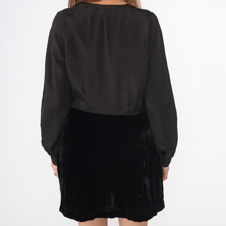 May include: A black velvet mini skirt with a black long-sleeved blouse.