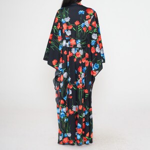 May include: A long black maxi dress with a floral print featuring red, blue, and white flowers. The dress has a V-neckline and long sleeves.