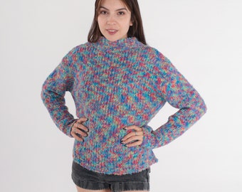 May include: A colorful, multi-colored, knit sweater with a high neck and long sleeves. The sweater is made of a soft, fuzzy yarn and has a relaxed fit.